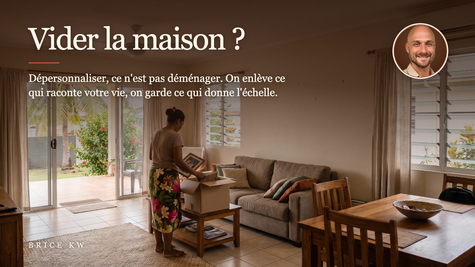 Une propriétaire range des photos de famille dans un carton, dans un salon meublé de Tahiti préparé pour les visites
